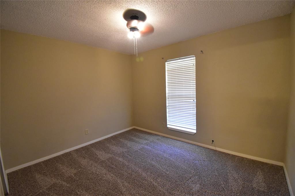5414 Castleview Lane Garland, TX 75044 - Photo 12 of 20 Empty room with a textured ceiling and dark carpet
