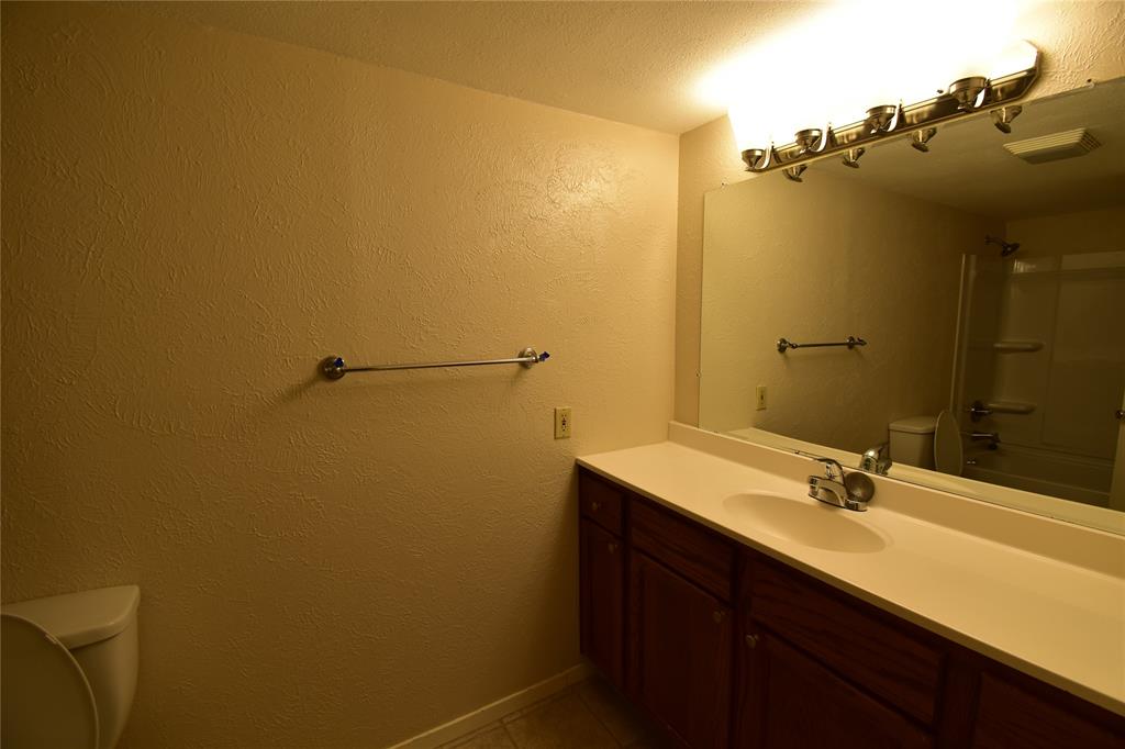 5414 Castleview Lane Garland, TX 75044 - Photo 17 of 20 Bathroom with a textured wall, vanity, shower / bath combination, and tile patterned flooring