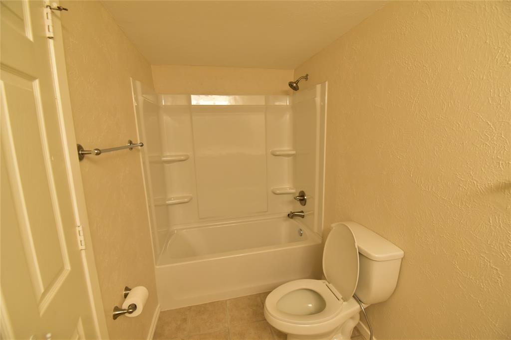 5414 Castleview Lane Garland, TX 75044 - Photo 18 of 20 Bathroom with a textured wall, light tile patterned flooring, and shower / washtub combination