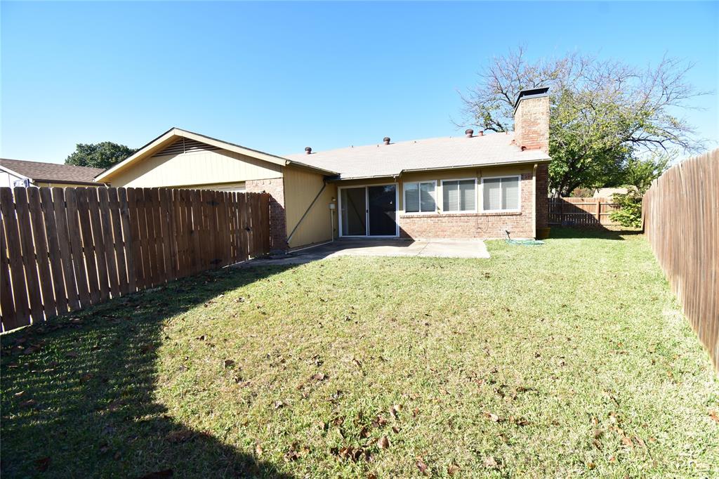 5414 Castleview Lane Garland, TX 75044 - Photo 20 of 20 Rear view of property featuring a chimney, a fenced backyard, a patio area, brick siding, and a sunroom