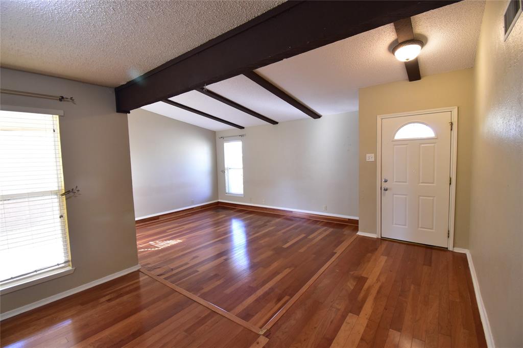 5414 Castleview Lane Garland, TX 75044 - Photo 2 of 20 Entrance foyer with dark wood-style floors and a textured ceiling