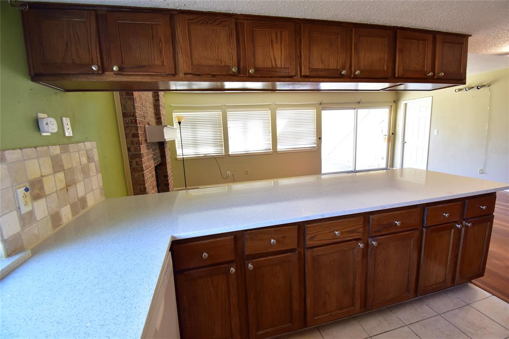 5414 Castleview Lane Garland, TX 75044 - Photo 9 of 20 Kitchen featuring light stone counters, light tile patterned flooring, and a textured ceiling
