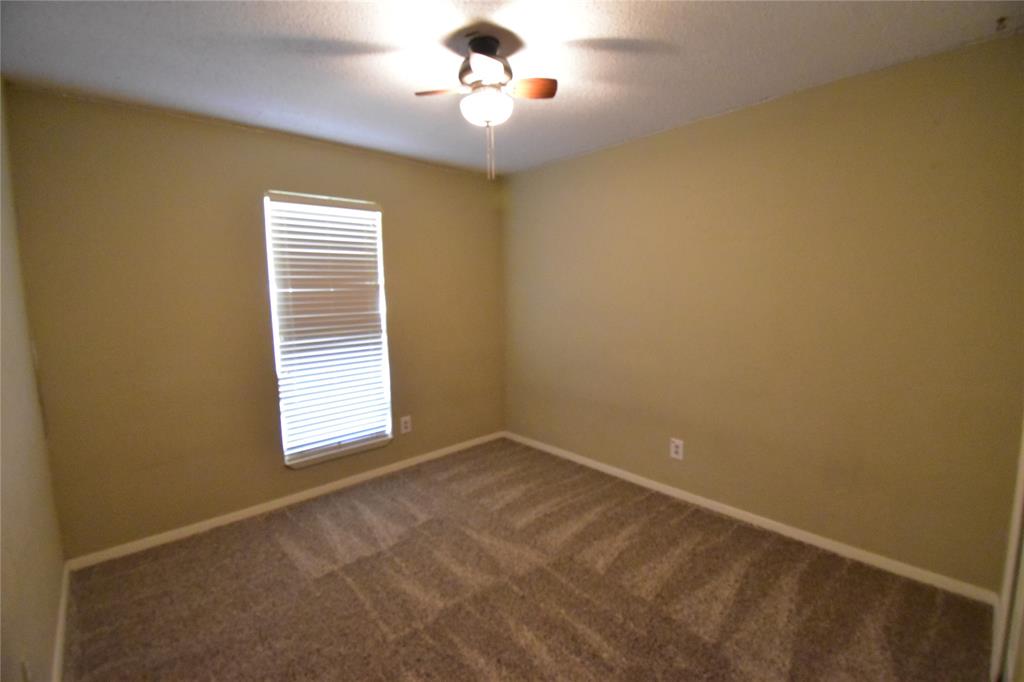 5414 Castleview Lane Garland, TX 75044 - Photo 10 of 20 Spare room with dark carpet, ceiling fan, and a textured ceiling