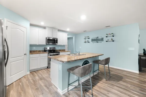 a kitchen with granite countertop a sink stove and refrigerator