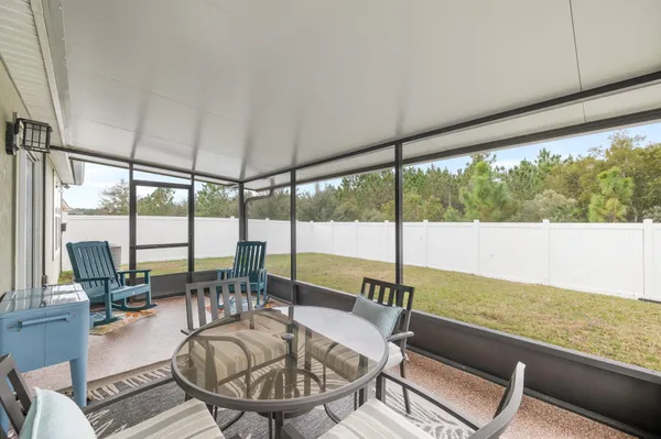 a living room with furniture tv and large windows