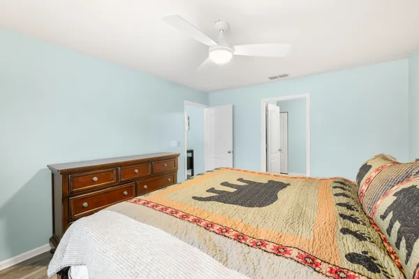 a bedroom with a bed and a dresser with rug
