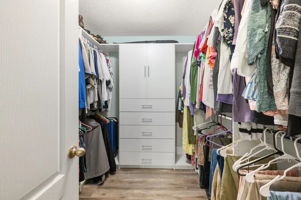 a view of walk in closet with clothes