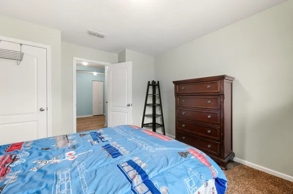 a bedroom with a bed and a dresser