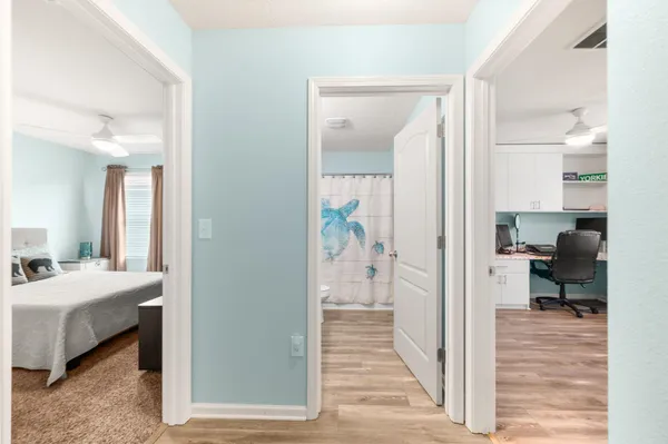a view of a bedroom with wooden floor and two bedroom