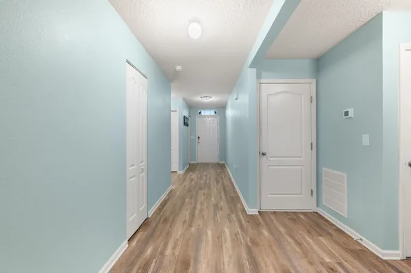 a view of a hallway with wooden floor