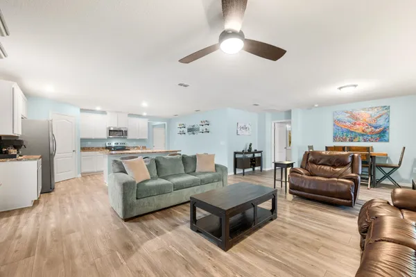 a living room with furniture and a view of kitchen