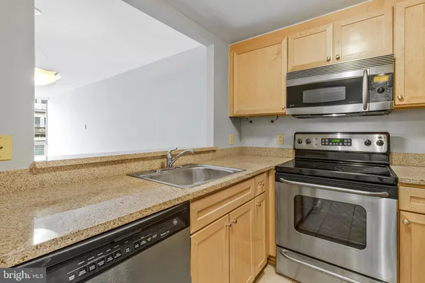 a kitchen with granite countertop a refrigerator and a stove top oven