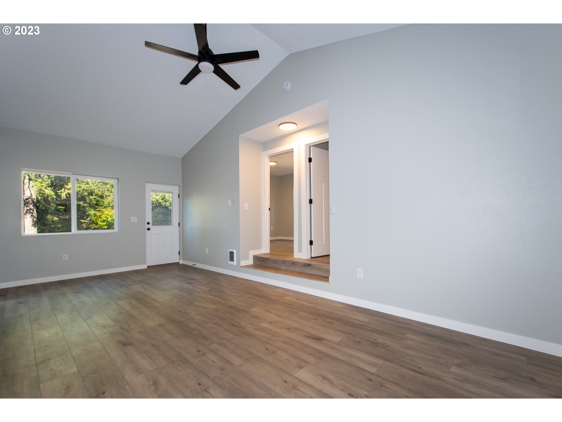 55 Moonshine Road Appleton, WA 98602 - Photo 6 of 33 an empty room with wooden floor a ceiling fan and windows