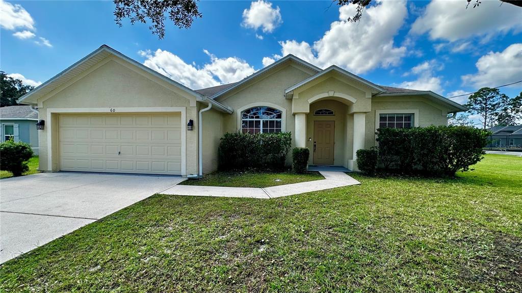 60 Pine Grove Drive Palm Coast, FL 32164 - Photo 1 of 20 a front view of a house with a yard and garage