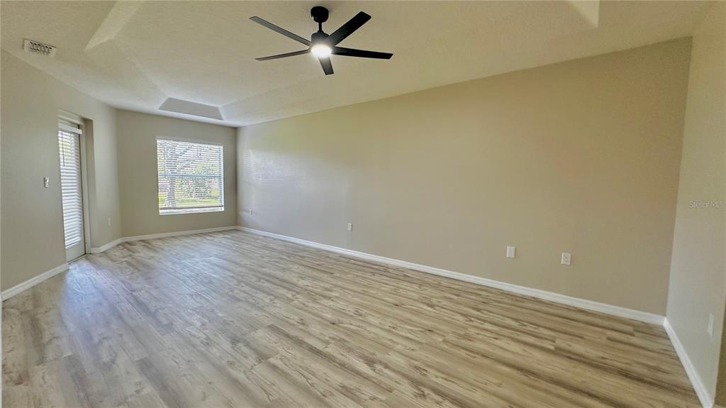 60 Pine Grove Drive Palm Coast, FL 32164 - Photo 14 of 20 an empty room with wooden floor and windows