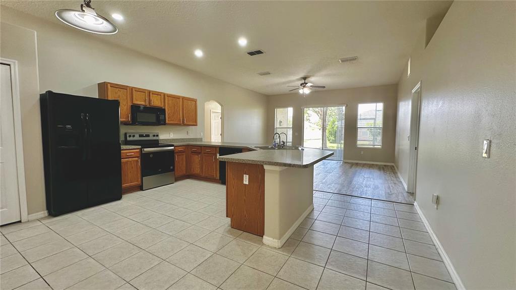 60 Pine Grove Drive Palm Coast, FL 32164 - Photo 18 of 20 a kitchen with stainless steel appliances granite countertop a refrigerator a sink a stove a microwave and island