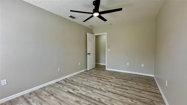 a view of room with wooden floor and ceiling fan