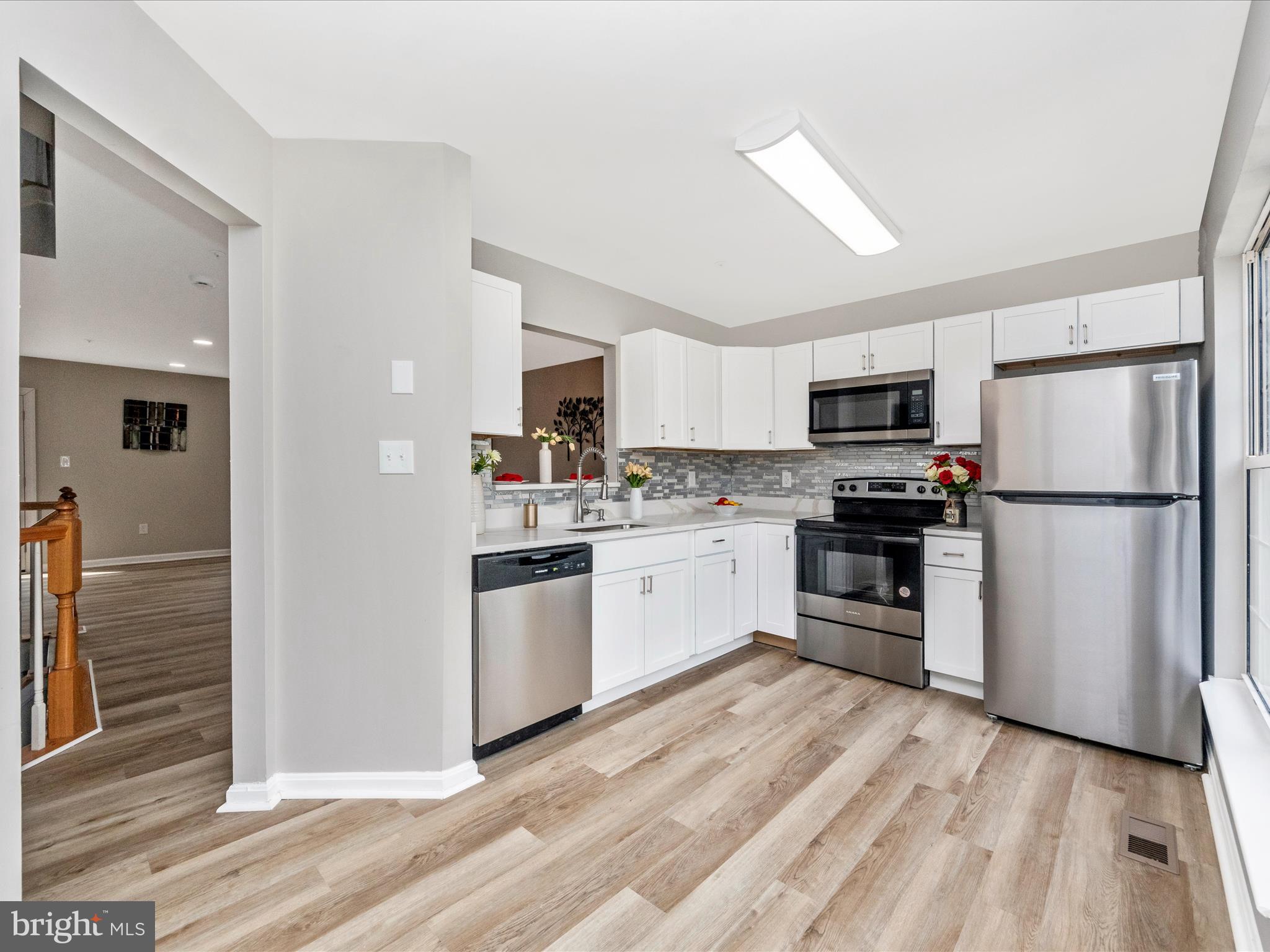 2242 Commissary Circle Odenton, MD 21113 - Photo 19 of 51 a kitchen with white cabinets stainless steel appliances and a refrigerator