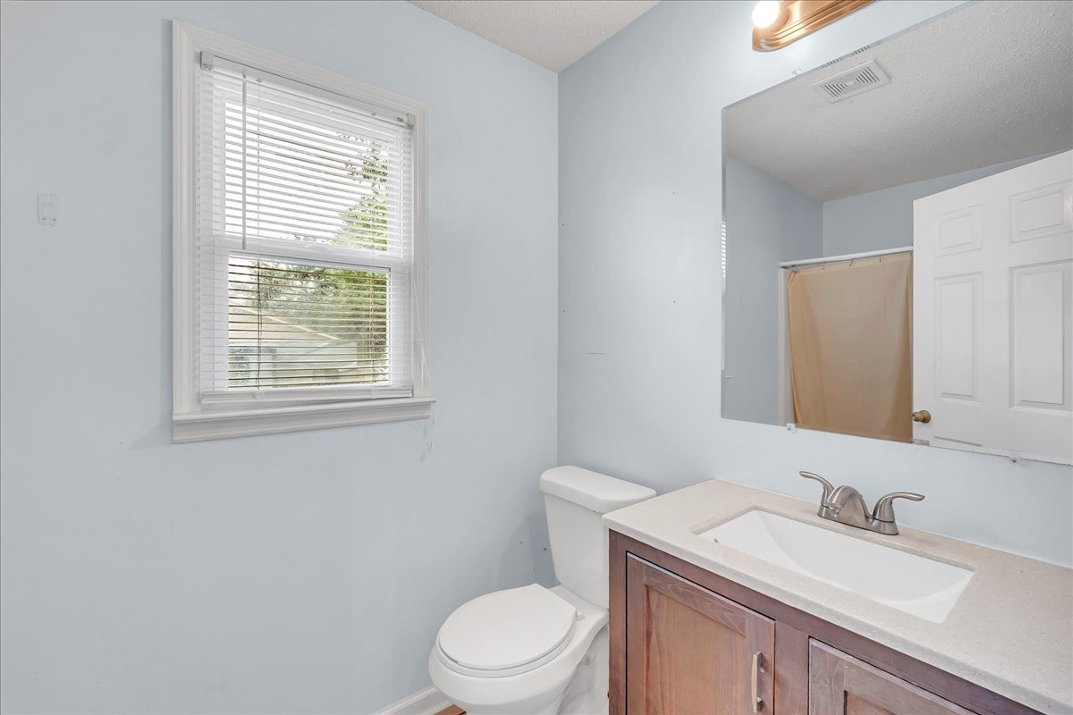 179 Eaton Heights Manchester, TN 37355 - Photo 19 of 33 a bathroom with a granite countertop toilet a sink a mirror and a window