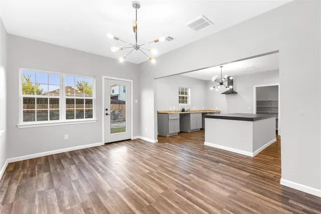 a view of a kitchen with wooden floor and a ceiling fan