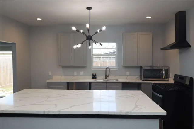 a large white kitchen with a sink a microwave a stove and refrigerator