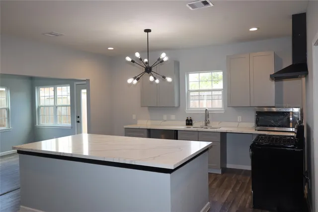 a kitchen with kitchen island a sink stainless steel appliances and window