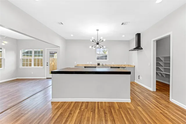 a living room with kitchen island granite countertop wooden floor and a fireplace