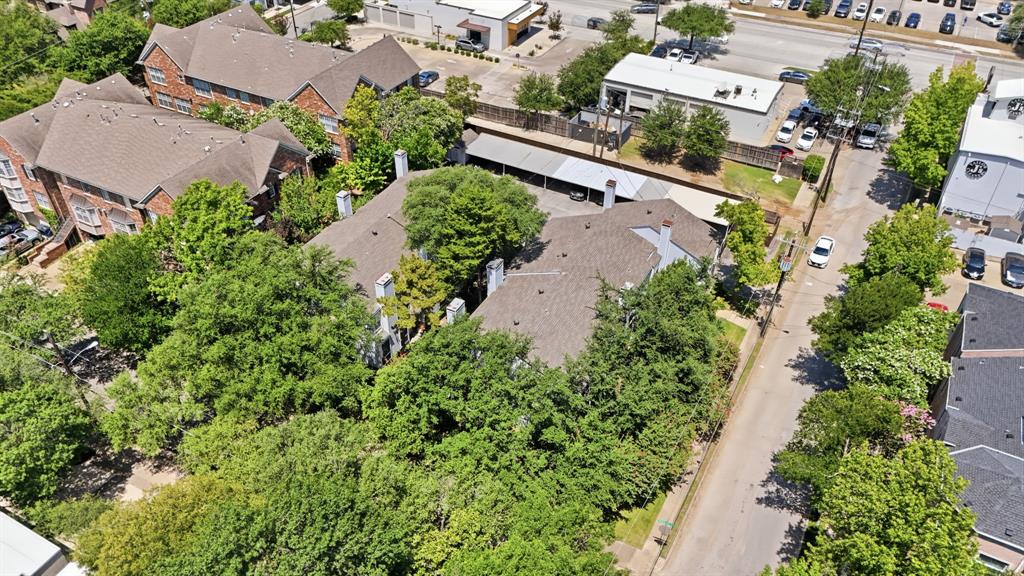 2815 Welborn Street, Unit 101 Dallas, TX 75219 - Photo 26 of 29 Multi-building property with pitched shingle roofs and extensive tree coverage