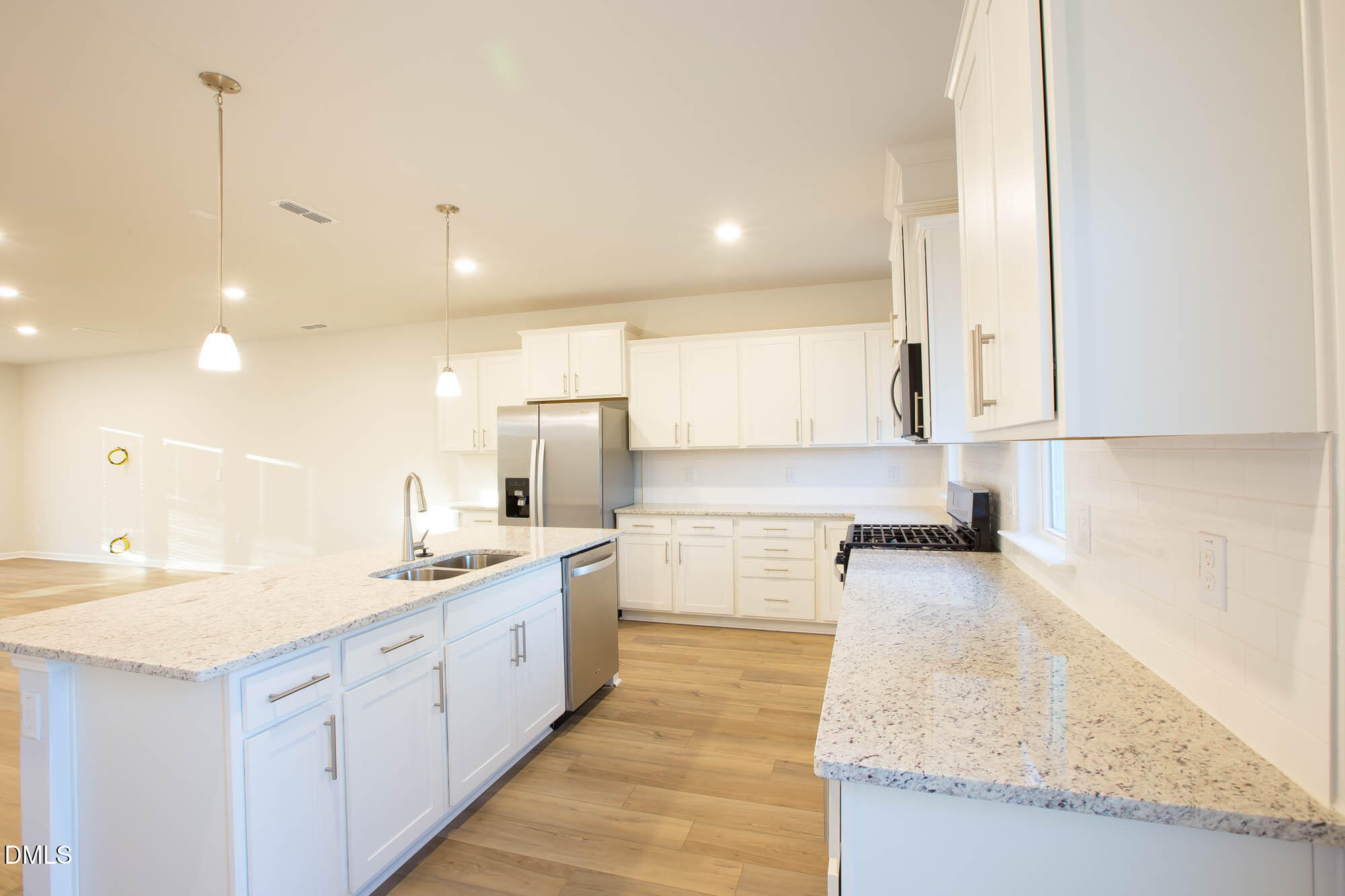 765 Larkspur Bowl Way Apex, NC 27523 - Photo 13 of 25 a large kitchen with kitchen island a sink stainless steel appliances and cabinets
