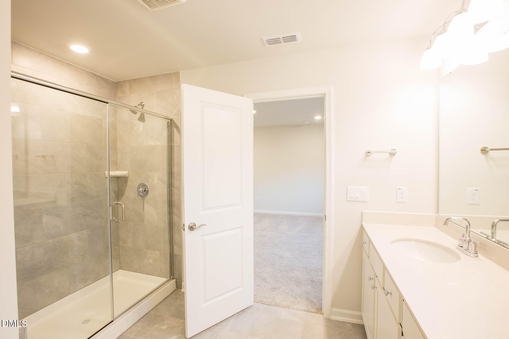 765 Larkspur Bowl Way Apex, NC 27523 - Photo 22 of 25 a bathroom with a granite countertop sink a mirror and shower