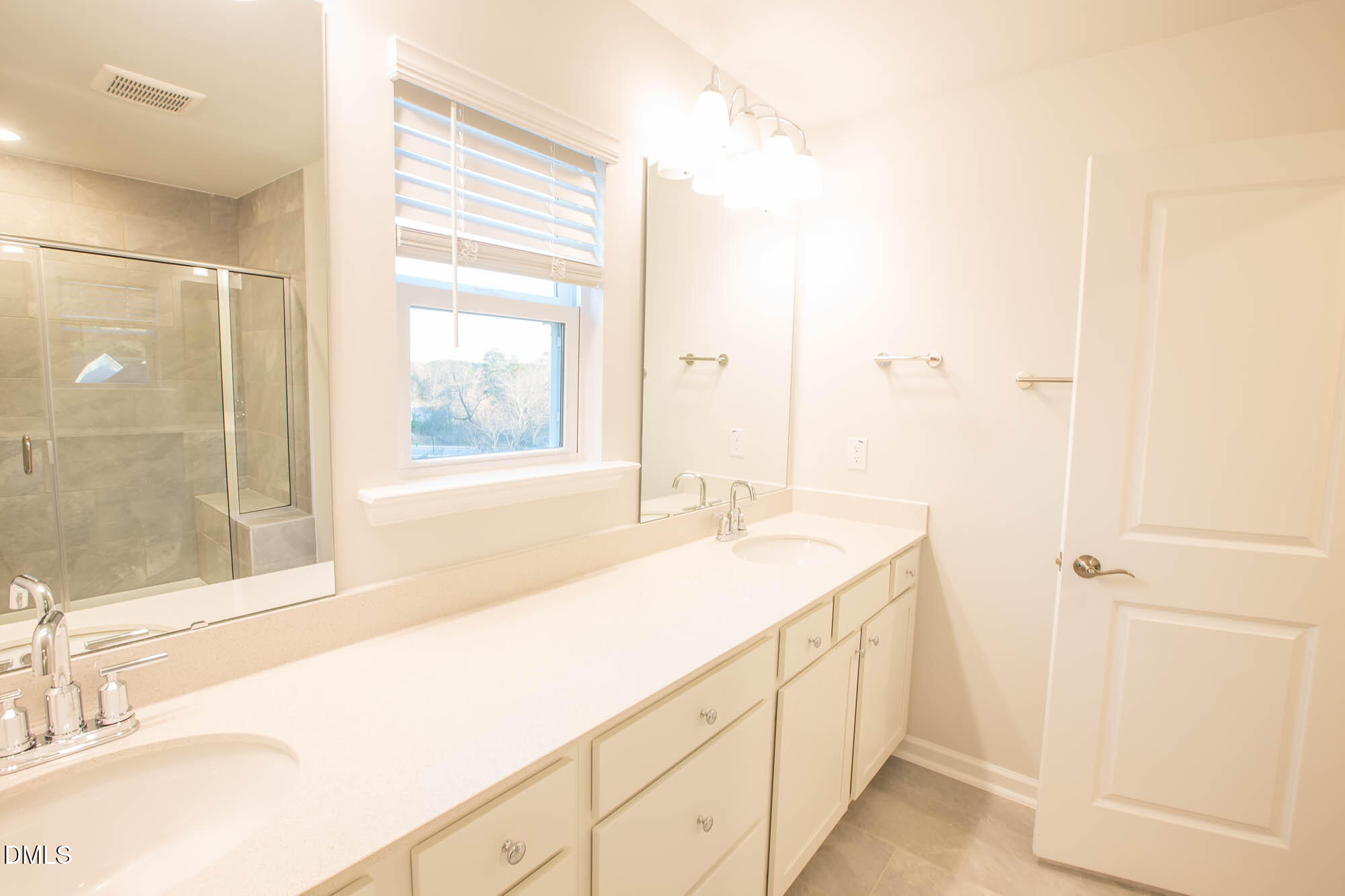765 Larkspur Bowl Way Apex, NC 27523 - Photo 24 of 25 a spacious bathroom with a granite countertop sink and a mirror