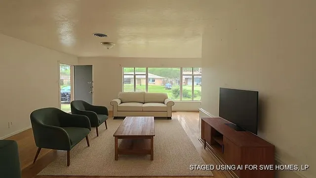 a living room with furniture wooden floor and a flat screen tv