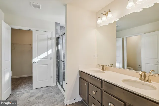 a bathroom with a double vanity sink mirror and shower