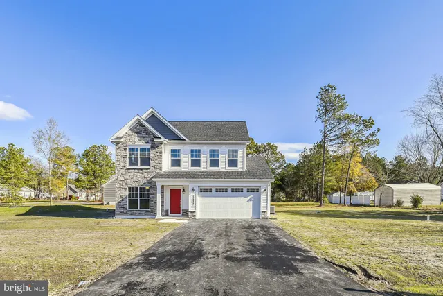a front view of a house with a yard and trees