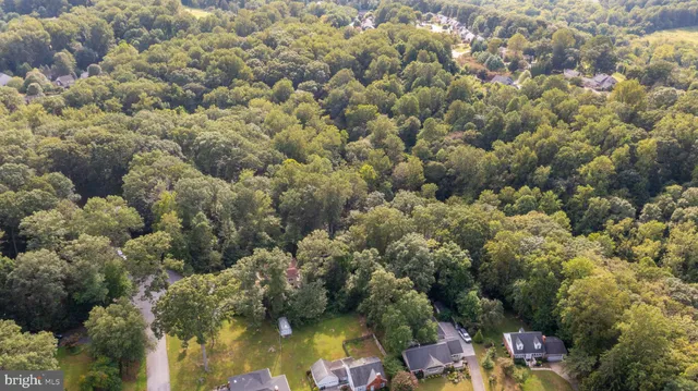 an aerial view of residential houses with outdoor space and trees