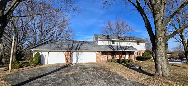 a view of a house with a tree next to a yard