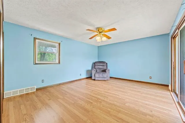 a view of empty room with wooden floor and fireplace