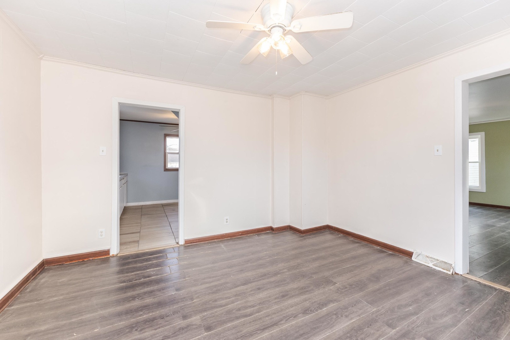 121 East James Street Forrest, IL 61741 - Photo 12 of 39 an empty room with wooden floor and fan