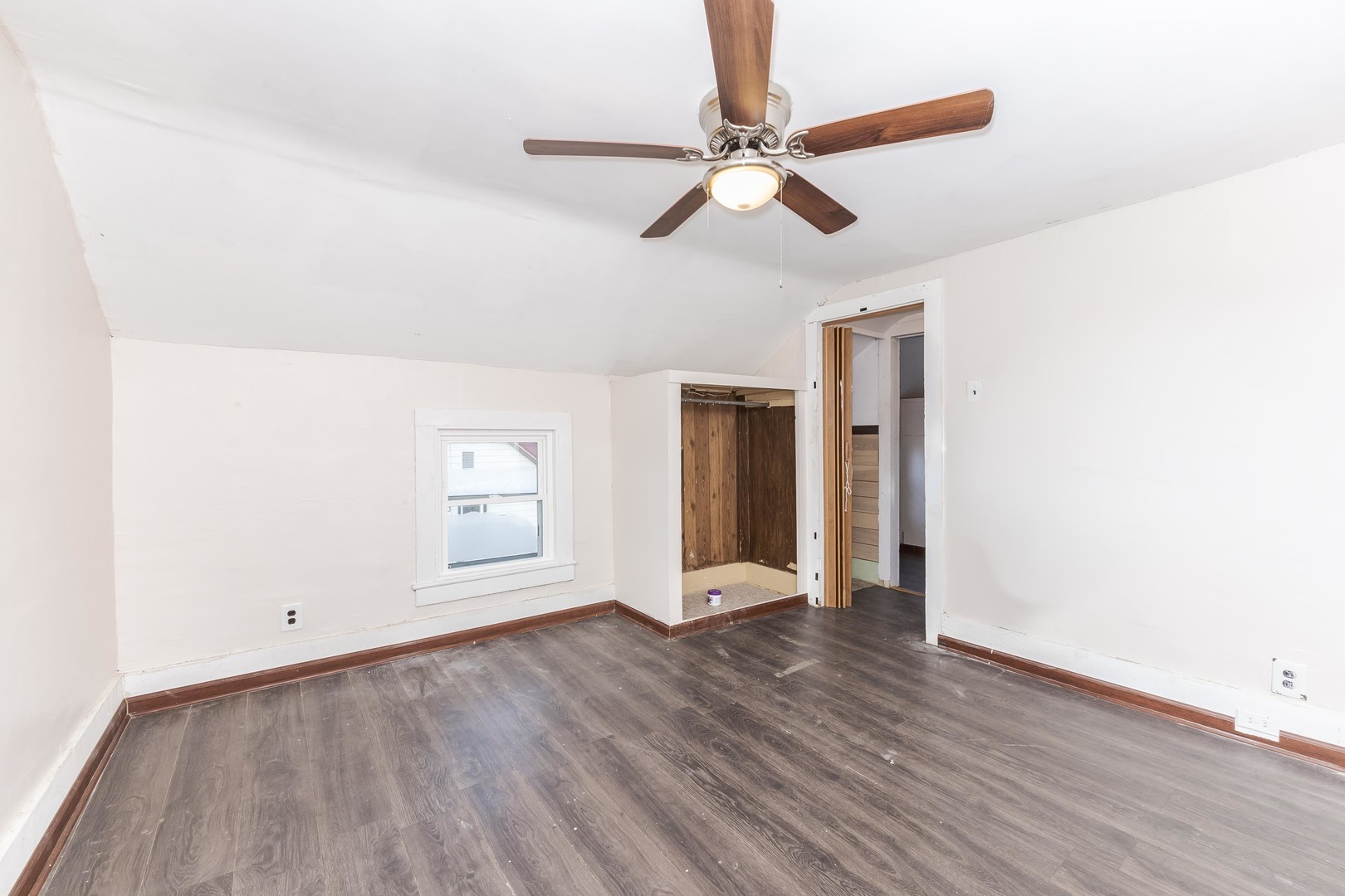 121 East James Street Forrest, IL 61741 - Photo 17 of 39 a view of an empty room with wooden floor and a ceiling fan
