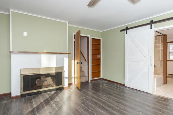 a view of an empty room with a fireplace and a window