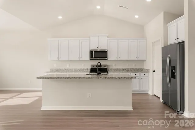 a kitchen with a refrigerator and a stove top oven