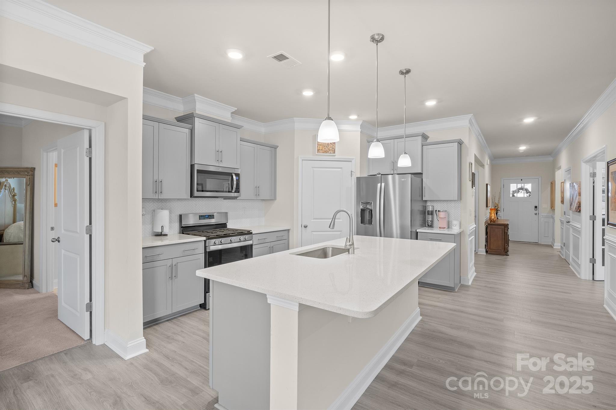 106 South Shayna Road Troutman, NC 28166 - Photo 6 of 41 a large white kitchen with a refrigerator a stove top oven a sink a center island and couches