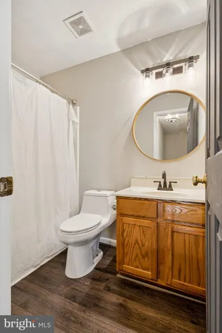 a bathroom with a toilet a sink and mirror