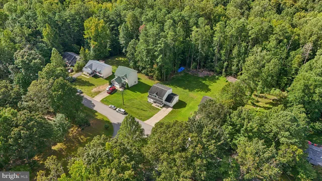 an aerial view of a house with a yard and trees