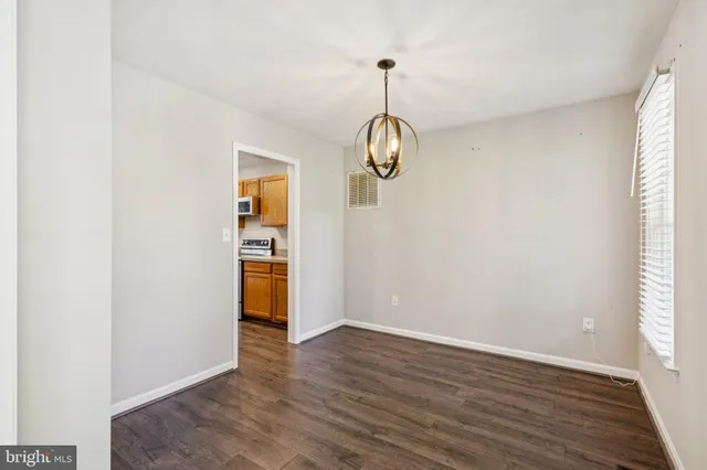 a view of empty room with wooden floor and window