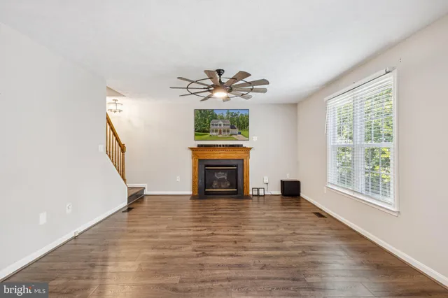 a view of an empty room with window and fireplace