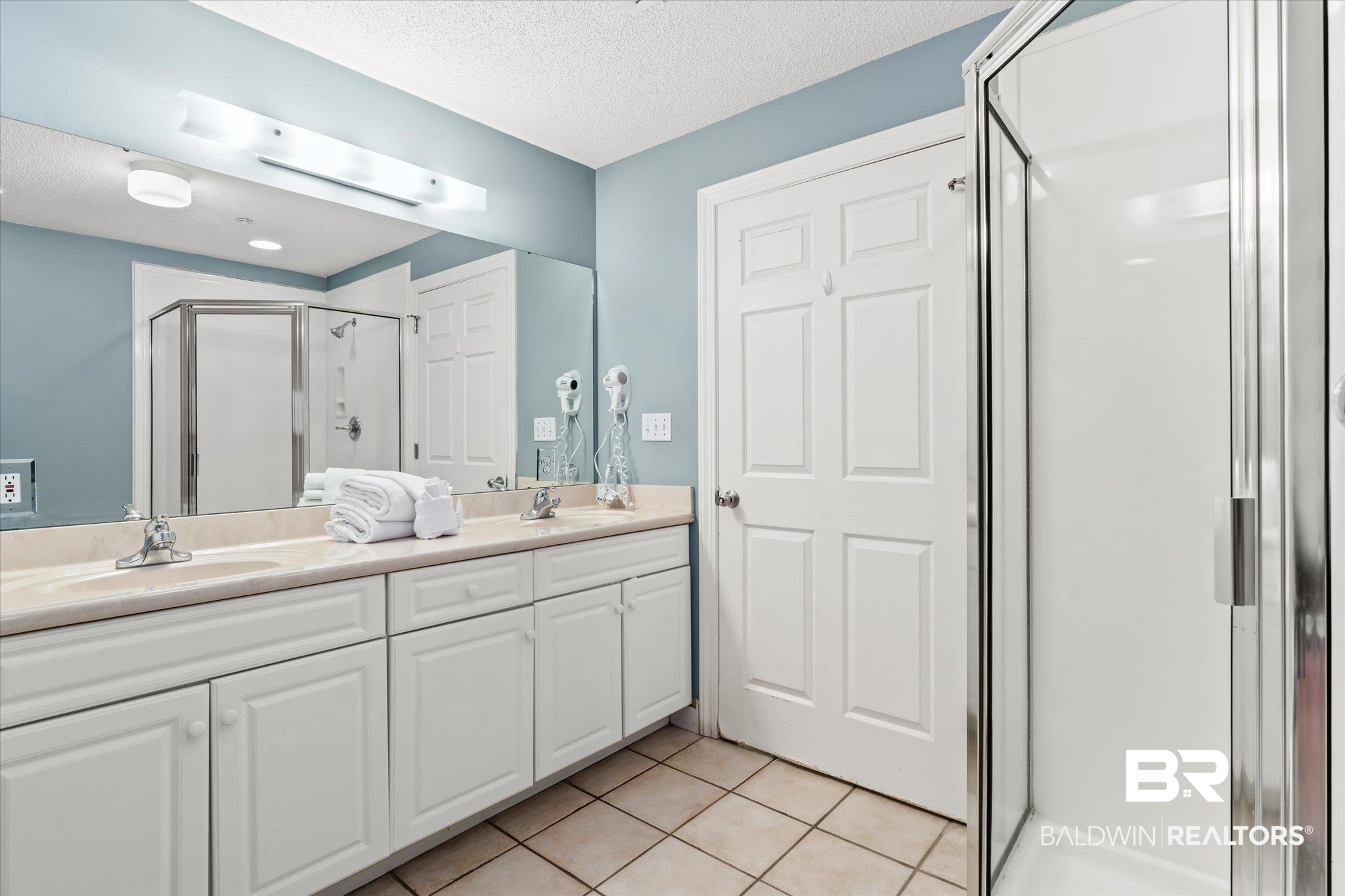 27580 Canal Road, Unit 1322 Orange Beach, AL 36561 - Photo 14 of 30 Bathroom featuring vanity, a textured ceiling, walk in shower, and tile patterned floors