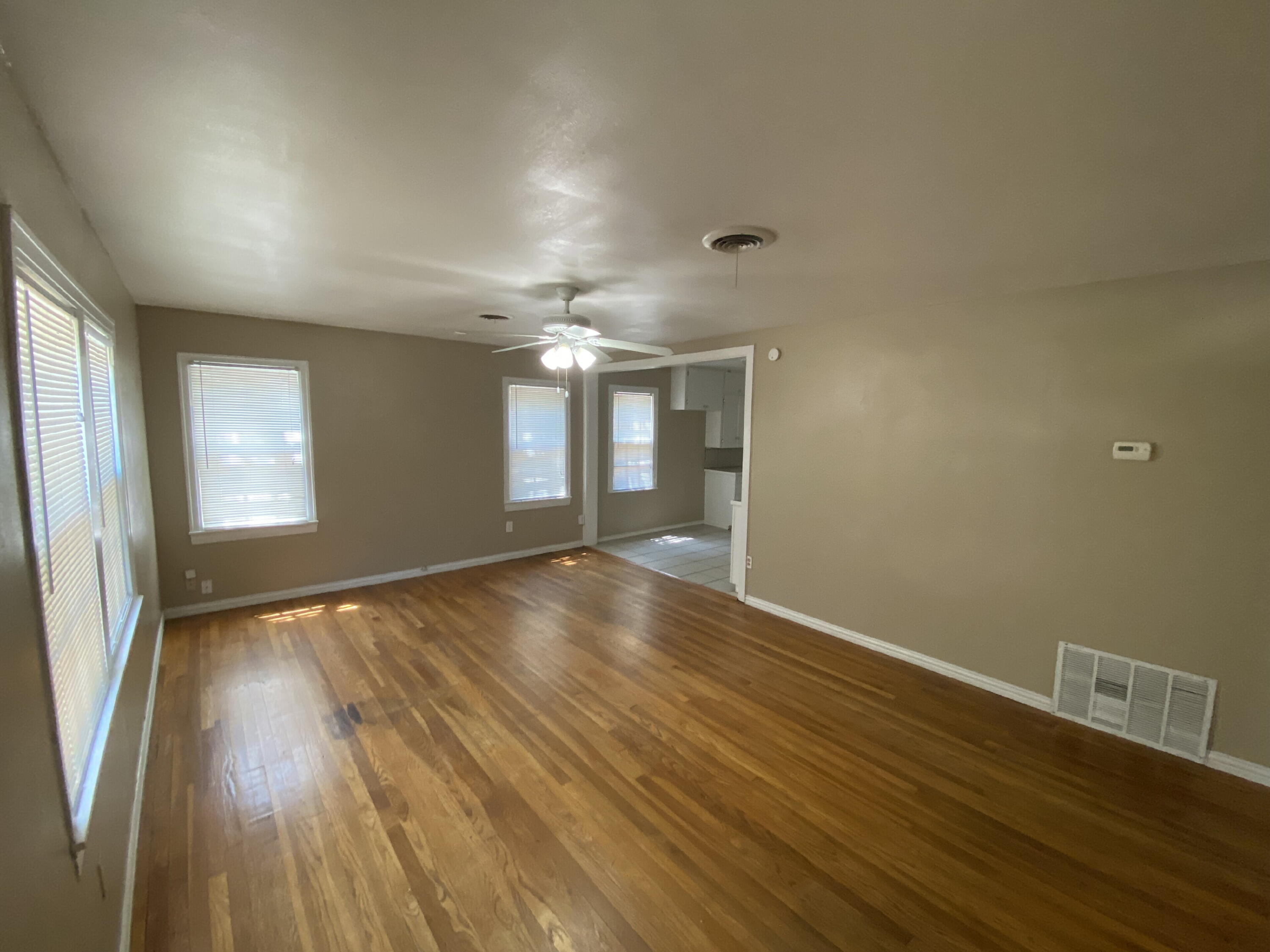 2520 27th Street, Unit FRONT Lubbock, TX 79410 - Photo 2 of 17 an empty room with wooden floor and windows