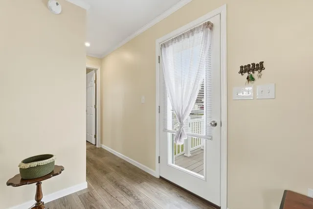 a view of a hallway with wooden floor and a cabinet