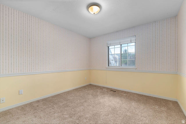 1822 East 9800th Street South Sandy, UT 84092 - Photo 32 of 38 Empty room with wallpapered walls and carpet flooring